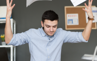 Man frustrated with spreadsheets and paperwork